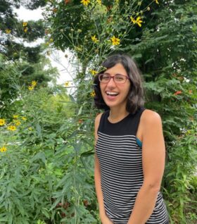 Mozhgon Rajaee poses for a photo next to flowers