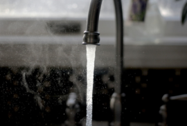 A stream of water pours from a kitchen faucet