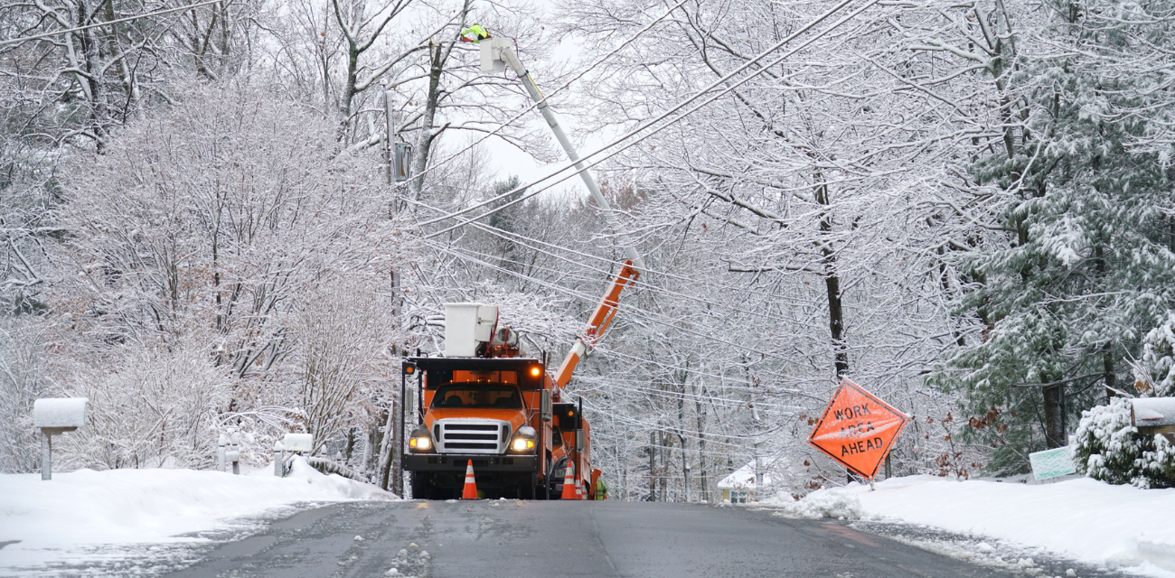 A worker repairs an electrical line after a winter snow storm (Photo via Adobe)