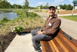 AJ Birkbeck Scholarship winner Ethan Coffin sits at a park bench near the Rogue River (Photo courtesy of Lynn McIntosh)