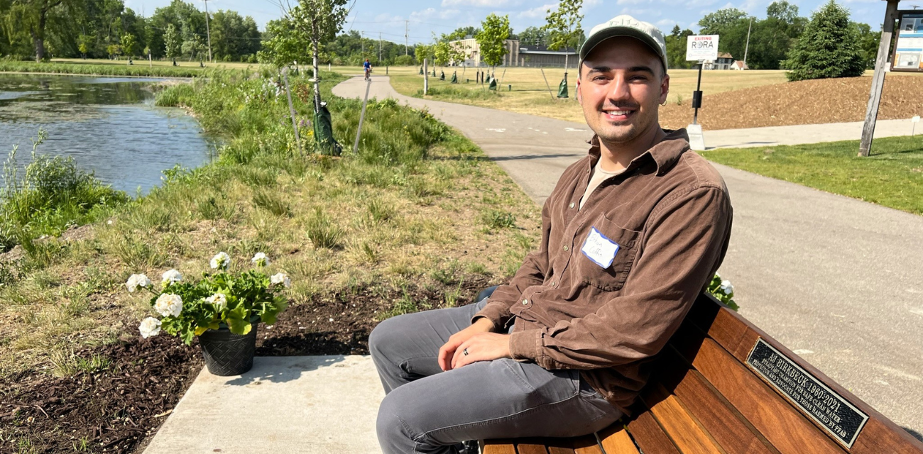 AJ Birkbeck Scholarship winner Ethan Coffin sits at a park bench near the Rogue River (Photo courtesy of Lynn McIntosh)