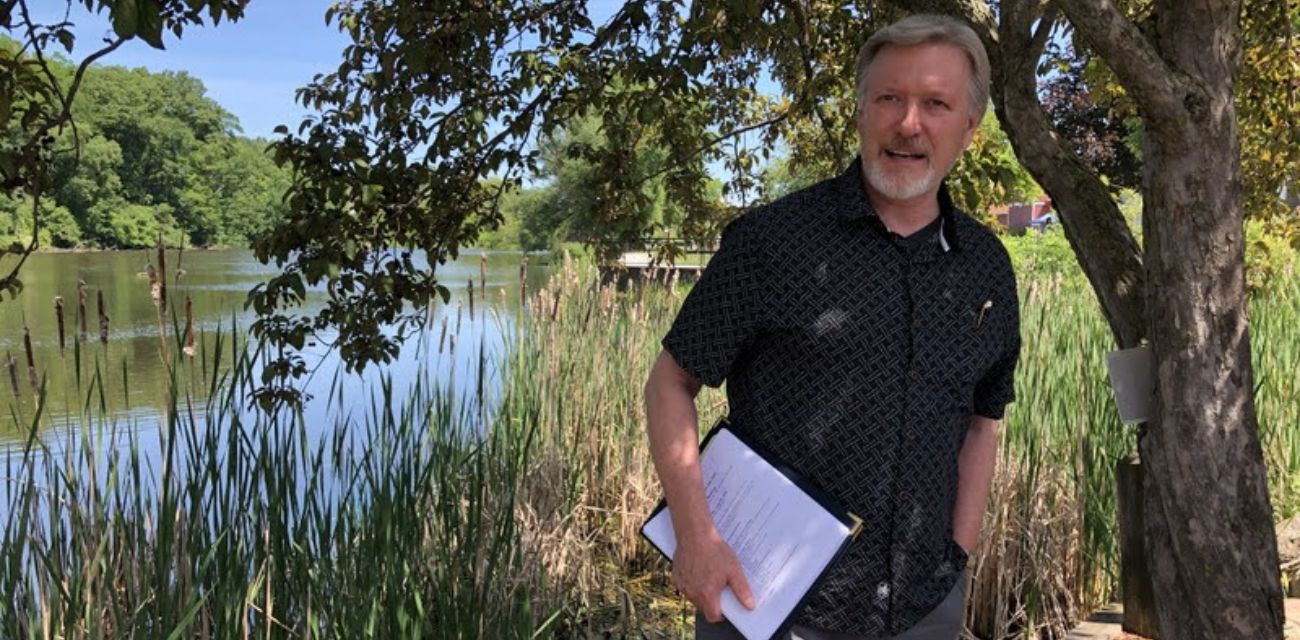 AJ Birkbeck gives a talk about PFAS at the Rogue River (Photo courtesy of MLive)