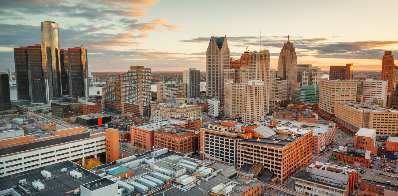 Buildings of Detroit's skyline are cast ochre colors in the setting sun