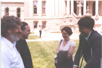 Megan Owens, Conan Smith, and others laugh in front of the Capitol after a press event in 2003.jpg