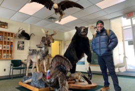 Outdoor recreation leader Brad Garmon poses with taxidermy of Michigan animals