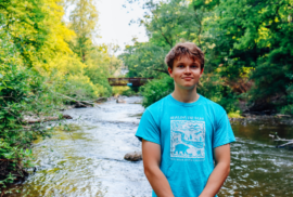 Tommy Skinner poses at a bend in the Bear River in Petoskey