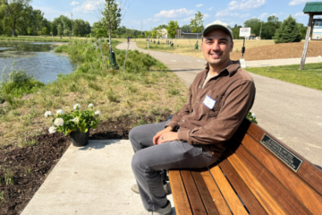 Ethan Coffin sits on a Rockford bench made in honor of AJ Birkbeck, the man behind Coffin's scholarship.