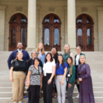 Advocates from the Michigan Alliance for Lead Safe Homes post smiling on the Michigan Capitol steps having recently passed landmark lead poisoning prevention bills.