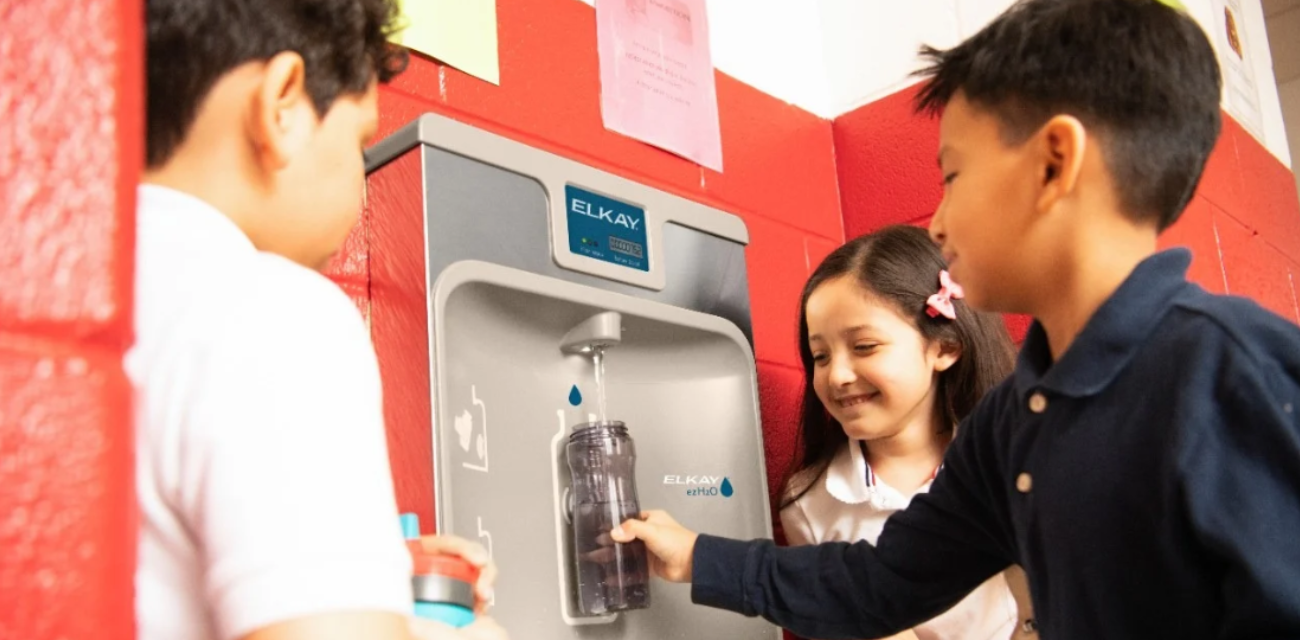 A child fills their water bottle at a water station while peers watch (Photos courtesy of Elkay)