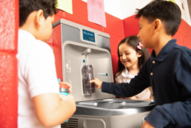 A child fills their water bottle at a water station while peers watch (Photos courtesy of Elkay)