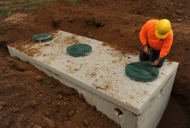 A man installs a septic tank (Photo via Adobe)