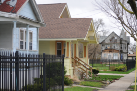 A row of bungalow houses reveal a blighted Saginaw home across the street