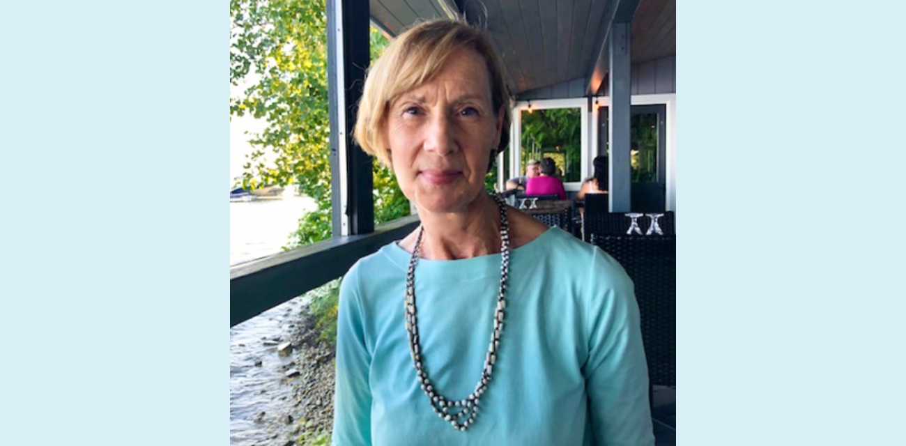 Sandy Sorini Elser poses for a photo by the water