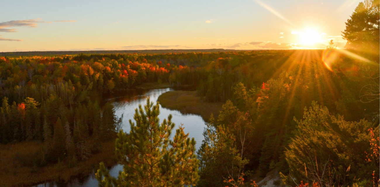 The Au Sable River shines blue amidst the ochre colors of autumn