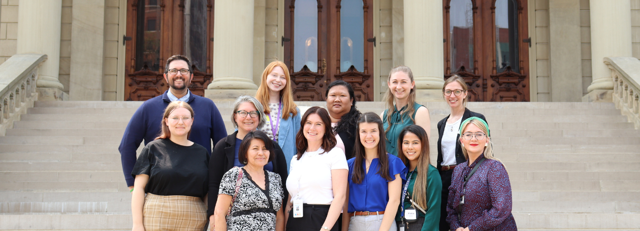 Advocates from the Michigan Alliance for Lead Safe Homes post smiling on the Michigan Capitol steps having recently passed landmark lead poisoning prevention bills.