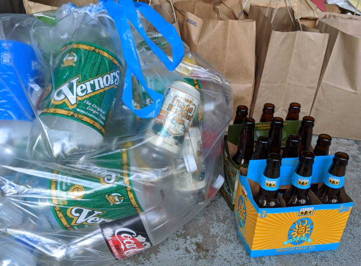 Vernors soda cans and Belle's Oberon bottles sit grouped in a bag and organizer, respectively, awaiting recycling