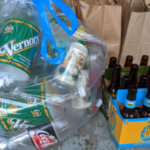 Vernors soda cans and Belle's Oberon bottles sit grouped in a bag and organizer, respectively, awaiting recycling