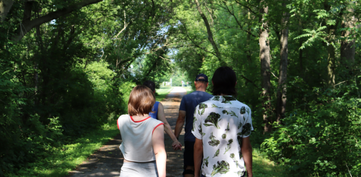 A family walks down the Macomb Orchard Trail toward Armada