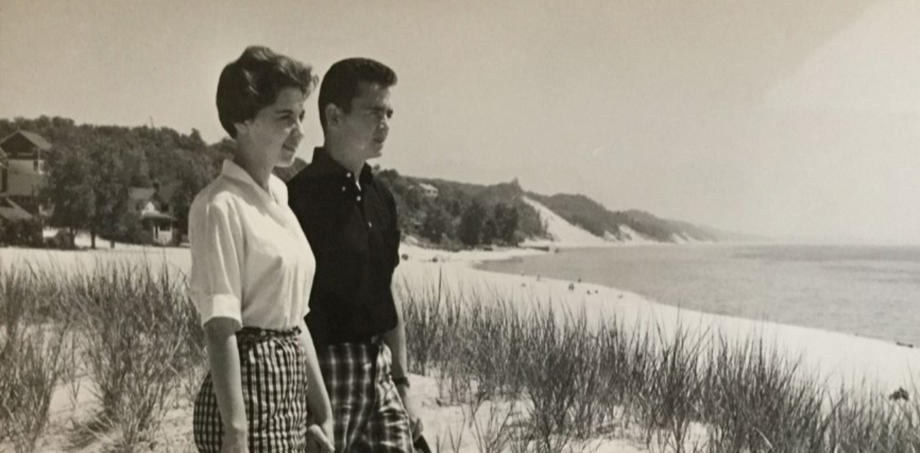 A woman and man stand atop a dune at Macatawa Beach. (Photo courtesy of the Archives of Michigan, 1962)