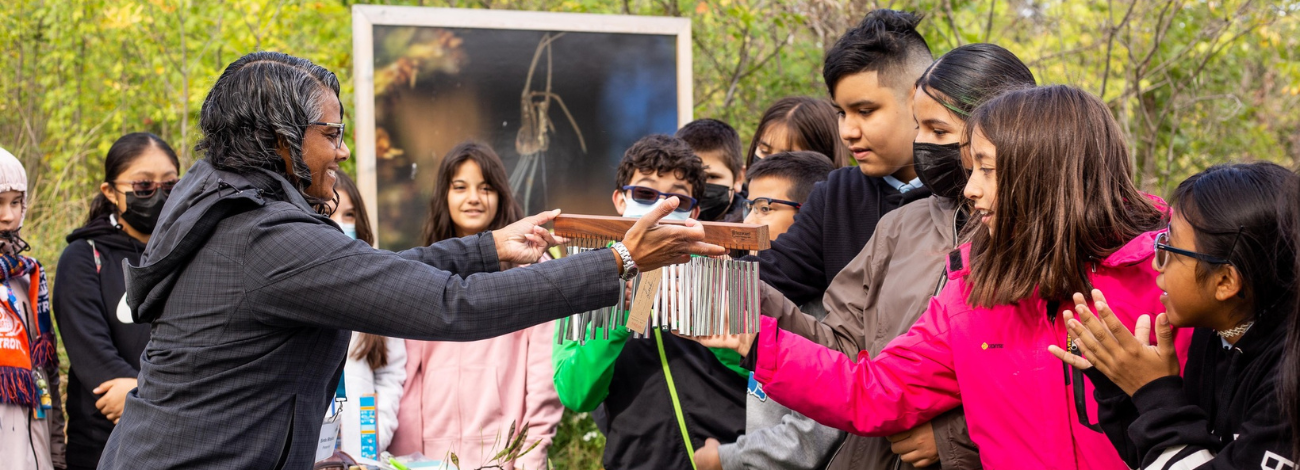 Friends of the Detroit River hosts the Detroit River Water Festival, showing a group of children a fun instrument.