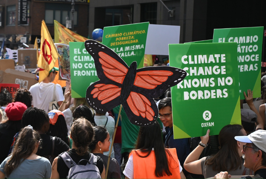 Climate rally members hold signs during a protest. (Photo courtesy of Oxfam.)