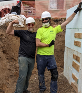 Conan Smith and Bill Wood flex their muscles at a construction site of Habitat for Humanity of Kent County