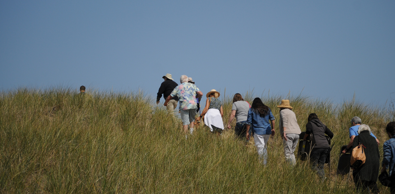 People walk up on a dune crest at Saugatuck's Oval Beach (Photo by Nate Mathewson)