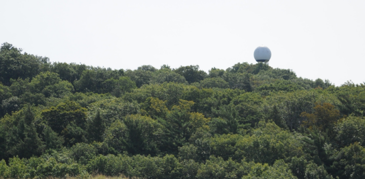 The Mount Baldhead radar tower rises above the treeline of a dunes ecosystem (Photo by Nate Mathewson)