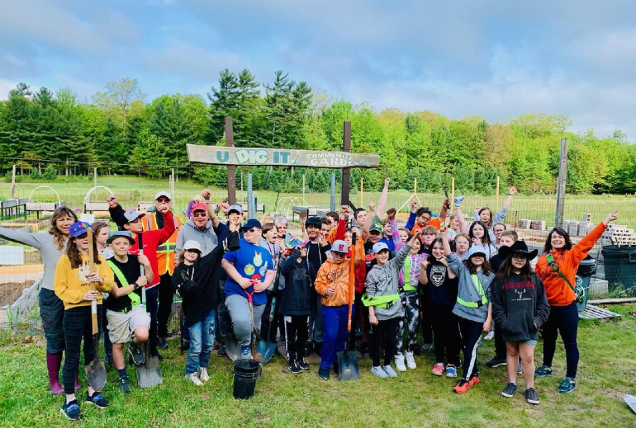 Children and adults pose for a group photo in front of U Dig It Community Garden in Ludington. (Photo courtesy of AFFEW.)