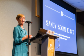 Sandy Sorini Elser speaks to a crowd after receiving the 2024 Petoskey Prize at Crystal Mountain in Thompsonville. (Photo by Beau Brockett.)