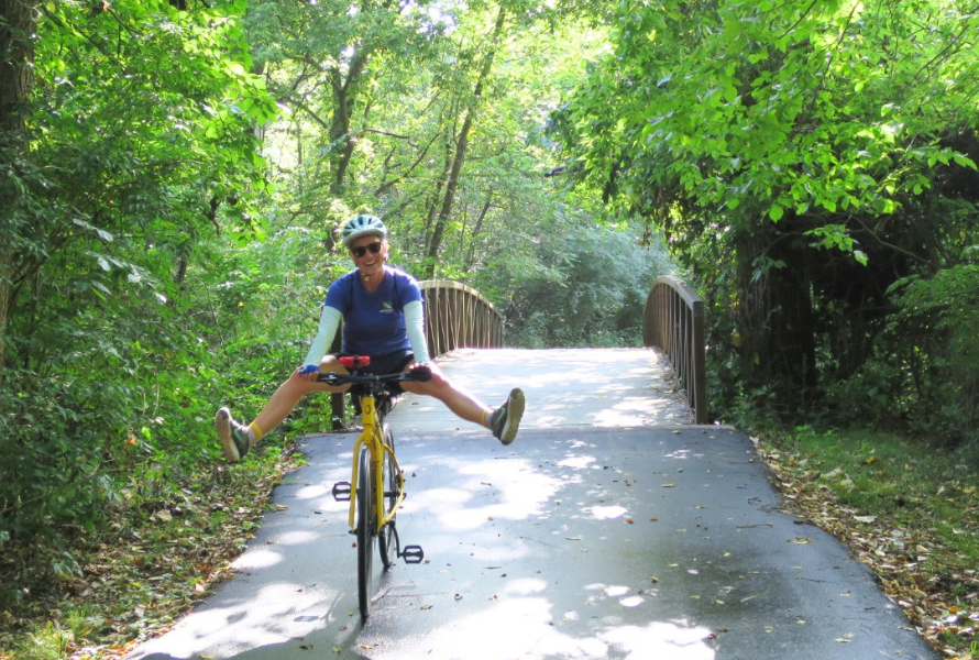 A woman does a trick on a bike along a former railway turned paved trail. (Photos courtesy of Rails to Trails Conservancy.)