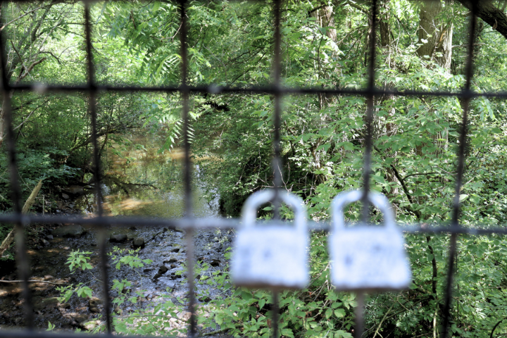 Two locks are hooked on a Macomb Orchard Trail bridge passing over the Coon Creek in Armada - Edited