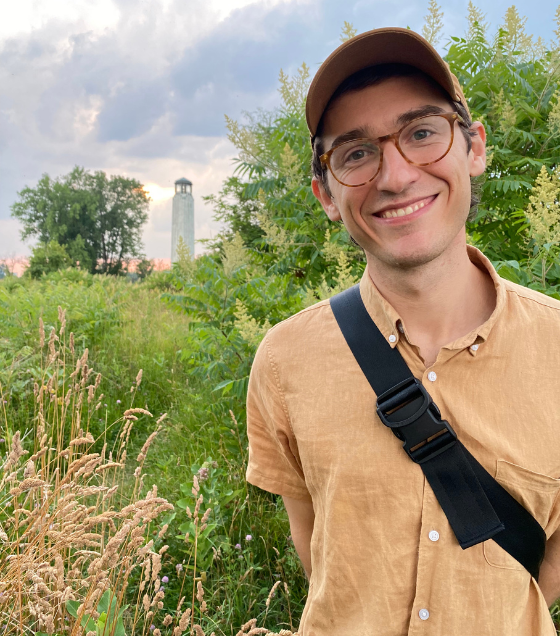 Cody Gallagher smiles in front of the Belle Isle Lighthouse