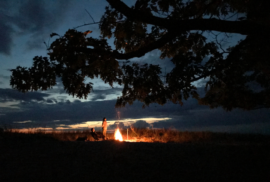 People gather at a fire along the dunes at night in Michigan