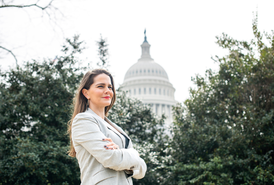 Lena Moffitt, executive director of Evergreen Action, poses in front of the United States Capitol and trees. (Photo courtesy of Evergreen Action)