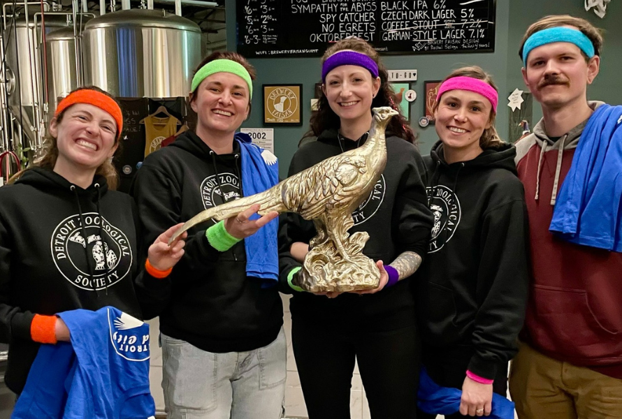 A winning bird trivia team shows off their prize- a gold-colored pheasant trophy. (Photo courtesy of Detroit Bird Alliance)