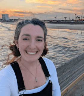 Meghann Carr smiles for a selfie by the water