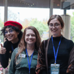 Reese Dillard, left, Samantha Pickering and Ellen Vial smile for the camera at the 2024 ECOSystems Conference at Crystal Mountain in Thompsonville