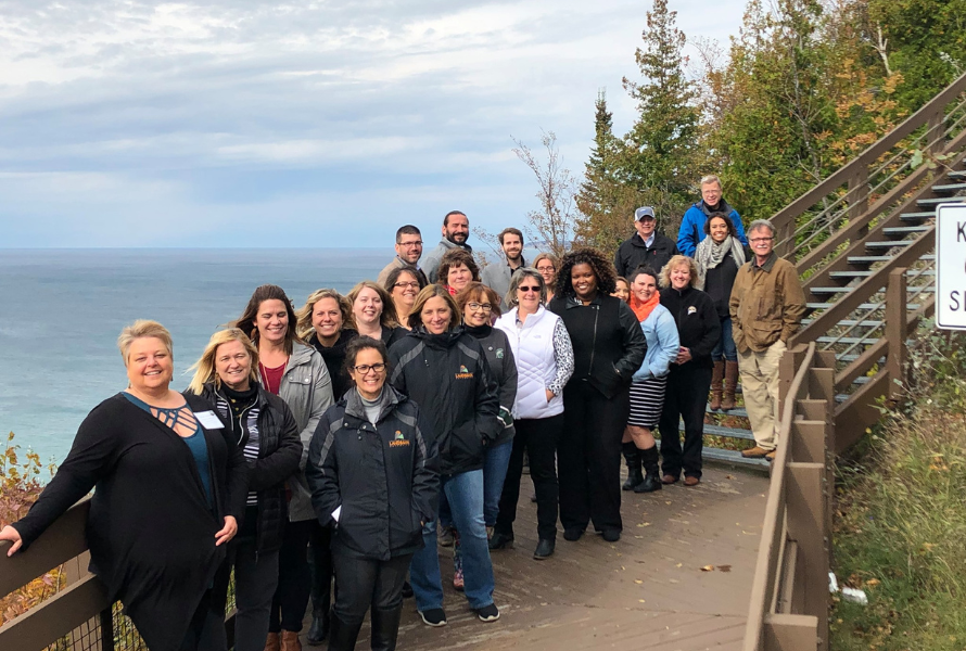 Members of the Michigan Association of Land Banks pose for a photo along a Great Lakes overlook. (Photo courtesy of Michigan Association of Land Banks)