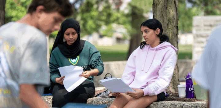 Aysha Uddin, center, and Anya Desai, right, work on articles for The Detroit Writing Room's student journalism camp. (Photo by Ella Miller for The Detroit Writing Room.)