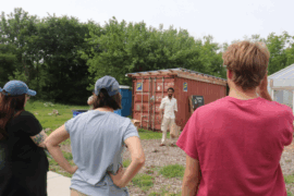 Krista Mickelson Beachnau (left), Megan Tinsley and Ryan Bohlen listen to a person at Sanctuary Farms in Detroit prep them for their field work.