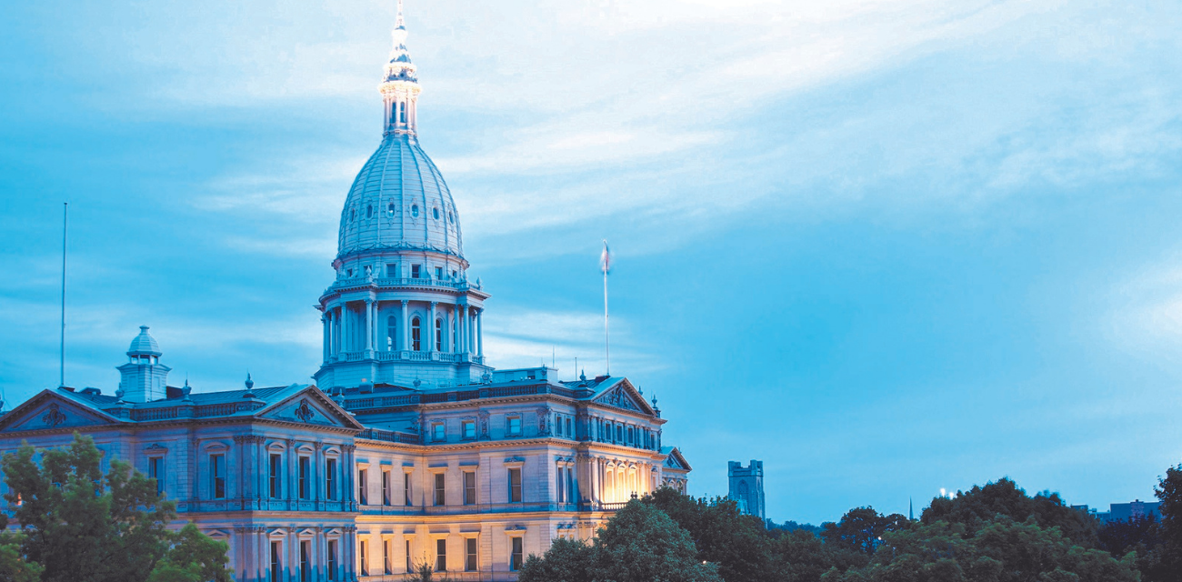 The Michigan Capitol is lit up by lights in twilight.