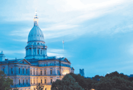 The Michigan Capitol is lit up by lights in twilght