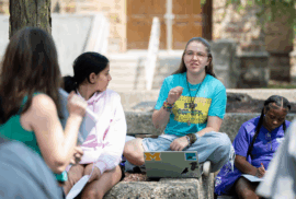 Willlow Lagrou, in blue, talks to students during The Detroit Writing Room's student journalism camp. (Photo by Photo by Ella Miller for The Detroit Writing Room.)