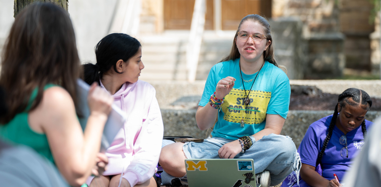 Willlow Lagrou, in blue, talks to students during The Detroit Writing Room's student journalism camp. (Photo by Photo by Ella Miller for The Detroit Writing Room.)