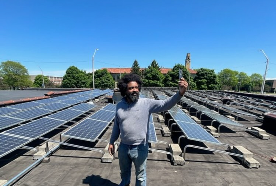 Jason Dixon stands atop of a Detroit job training facility with rows of solar panels. (Photo courtesy of Strategic Alliance Community Development Corporation)