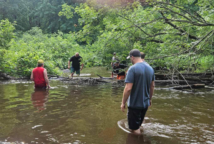 People wade through the Pine River to clear obstructions and debris. (Photo courtesy of Healthy Pine River)